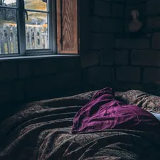 person laying on bed related to Purple Quilts & Coverlets: Warmth & Beauty in Every Shade