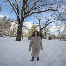 Photo by Olek Buzunov @buzunov.photoart. She is a Ukrainian singer living in NYC, captured during a personal winter photoshoot in Central Park. Surrounded by fresh snow and soft natural light, she interacts playfully with a snowman and poses among bare trees and city skyline views. The neutral tones of her coat contrast beautifully with the crisp white landscape, creating a calm, cozy atmosphere that blends urban life with seasonal serenity. related to Explore the Comfort and Style of Rooms to Go Full Size Beds