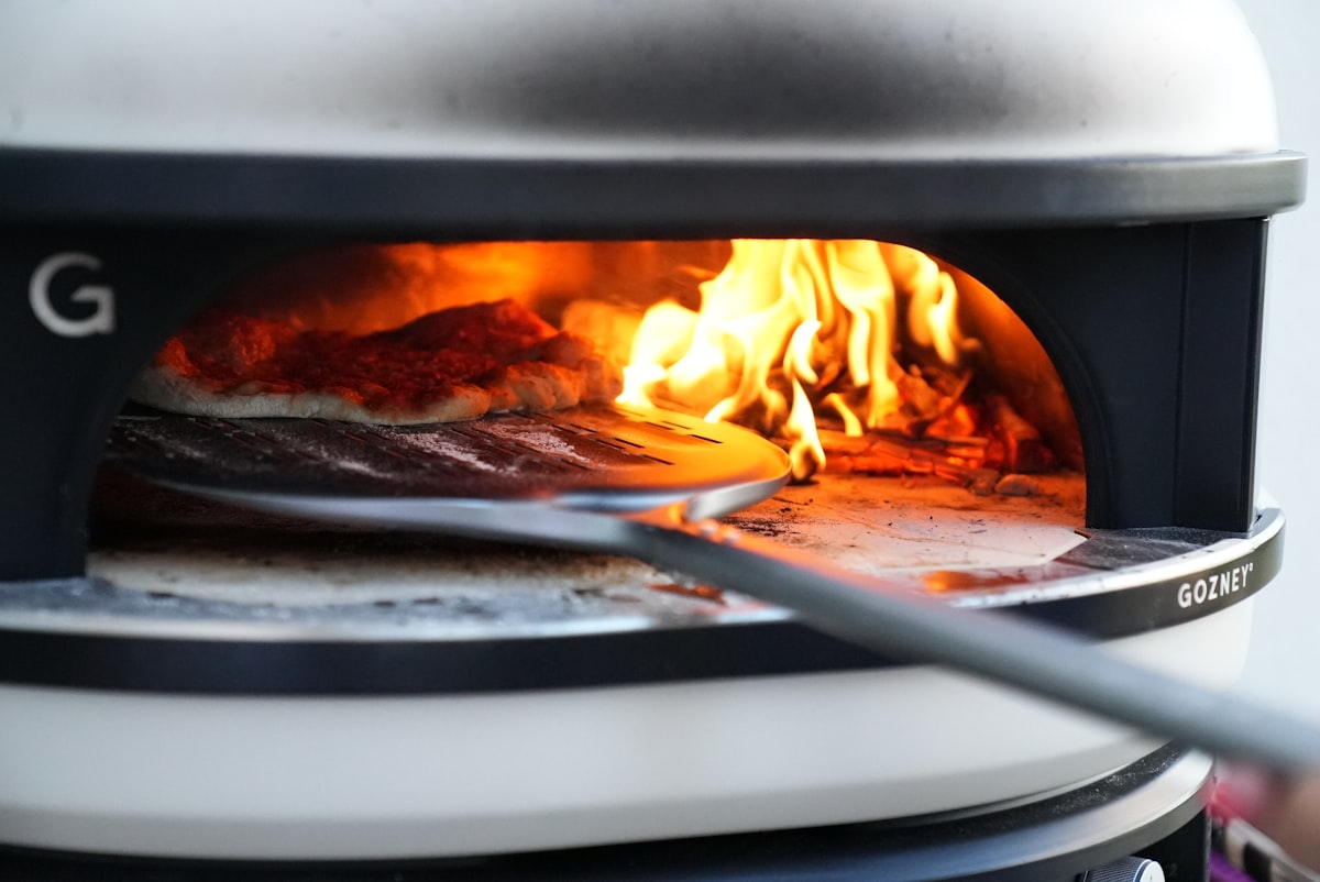 pizza being cooked in bbq oven related to Pizza Oven Chiminea: The Ultimate Outdoor Cooking Experience