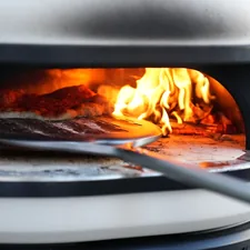 pizza being cooked in bbq oven related to Pizza Oven Chiminea: The Ultimate Outdoor Cooking Experience
