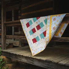 Quilt draped over a wooden porch railing related to Coverlets and Quilts Contemporary