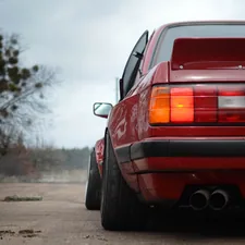 red car on gray asphalt road during daytime related to E30 Rear Valance: Upgrade Your BMW's Aesthetics