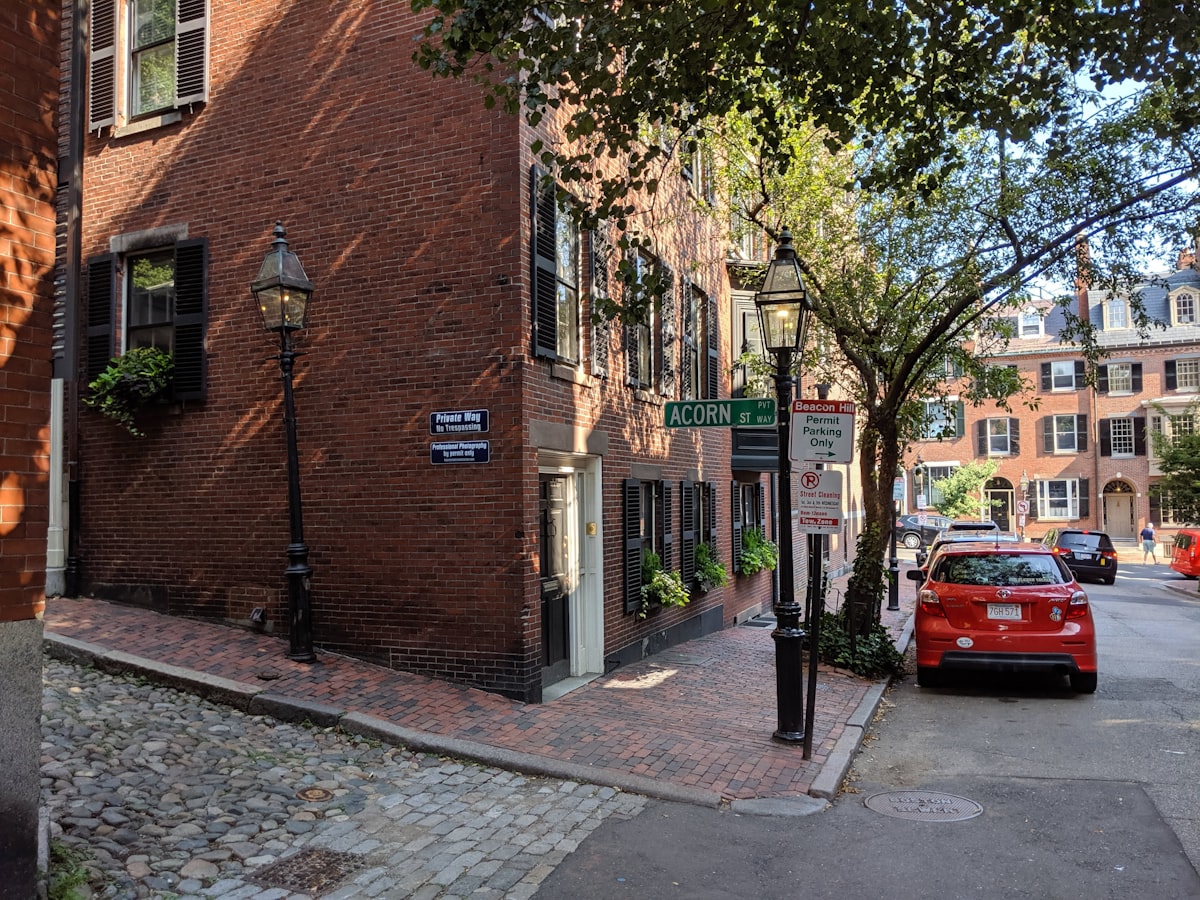 red car parked beside brown brick building related to Exploring the Charm of Bed and Breakfasts in Boston