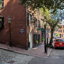 red car parked beside brown brick building related to Exploring the Charm of Bed and Breakfasts in Boston