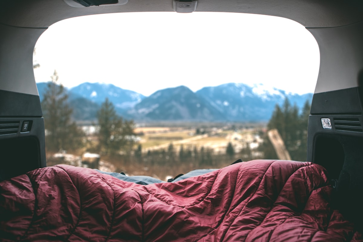 red comforter in gray structure related to Camping in Comfort: The Ultimate Guide to Inflatable Beds for Cars