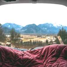 red comforter in gray structure related to Camping in Comfort: The Ultimate Guide to Inflatable Beds for Cars