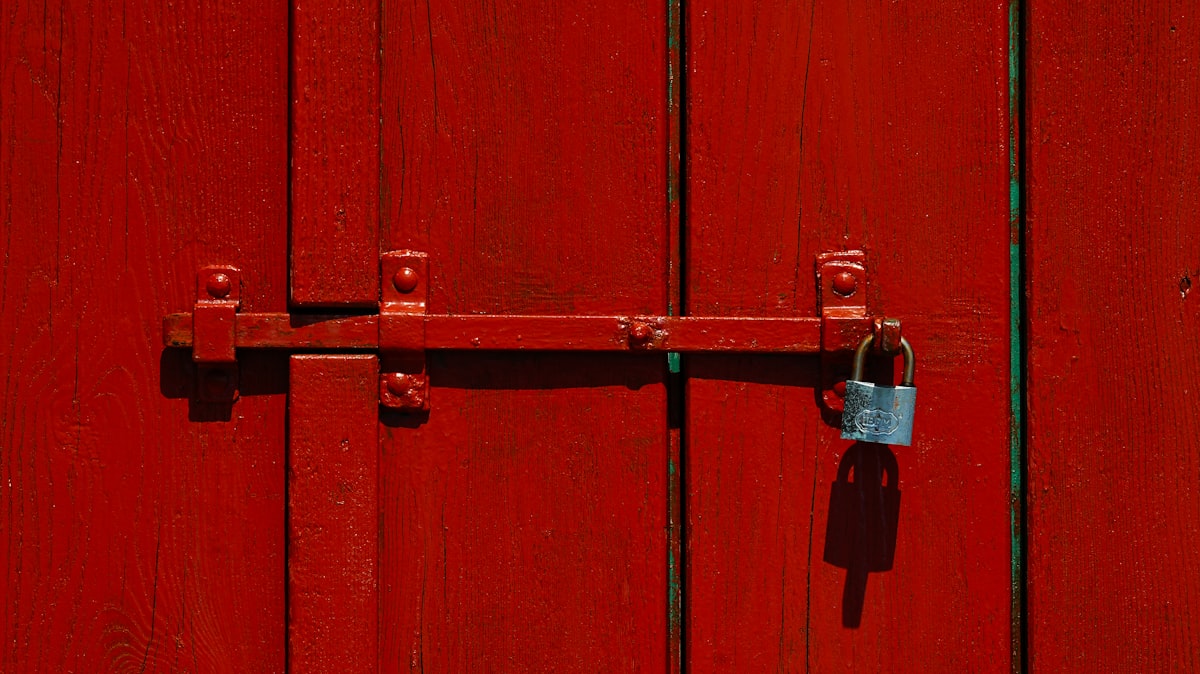 Red wooden door with a locked padlock related to Unlock Your Entryway Potential: DIY Locker Plans for Every Home