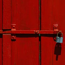 Red wooden door with a locked padlock related to Unlock Your Entryway Potential: DIY Locker Plans for Every Home