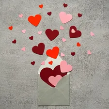 Rote und rosa Herzen fliegen aus einem Briefumschlag, Hintergrund grau. related to Dr. Seuss Valentine's Day