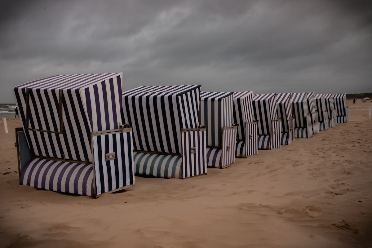 Row of striped beach chairs on a sandy beach related to The Ultimate Beach Bed Set: Comfort and Style by the Shore