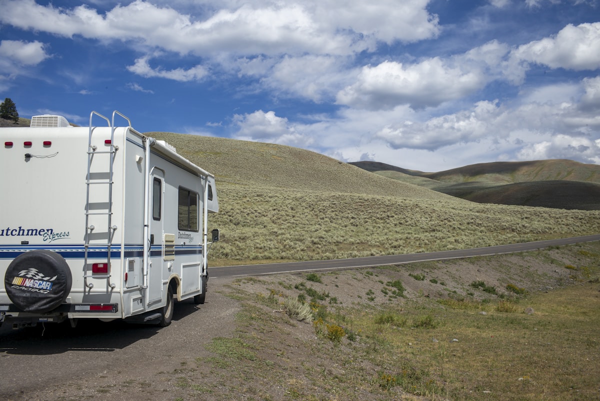 Rv parked on a dirt road with rolling hills. related to Choosing the Best Ladder for Your RV Bunk Bed