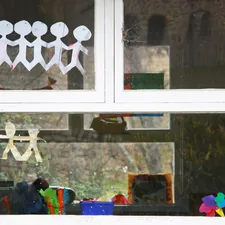 School window with paper cutouts and bright objects in the background. related to Elevate Your Window Game: A Guide to Simple Window Valances