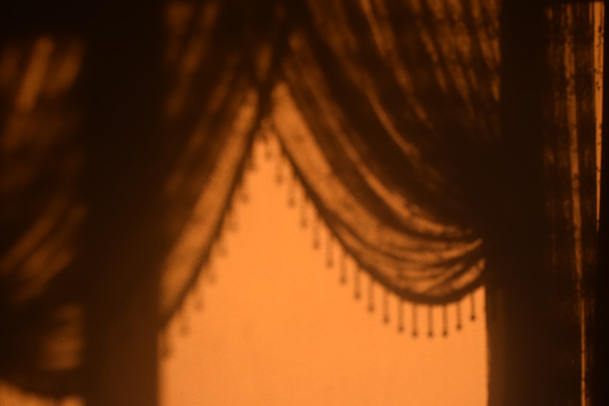 Shadows cast by draped curtains with beaded trim. related to Curtains, Valances, and Swags