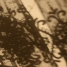 Shadows of ornate lace curtains cast on wall related to Lace Valances and Swags