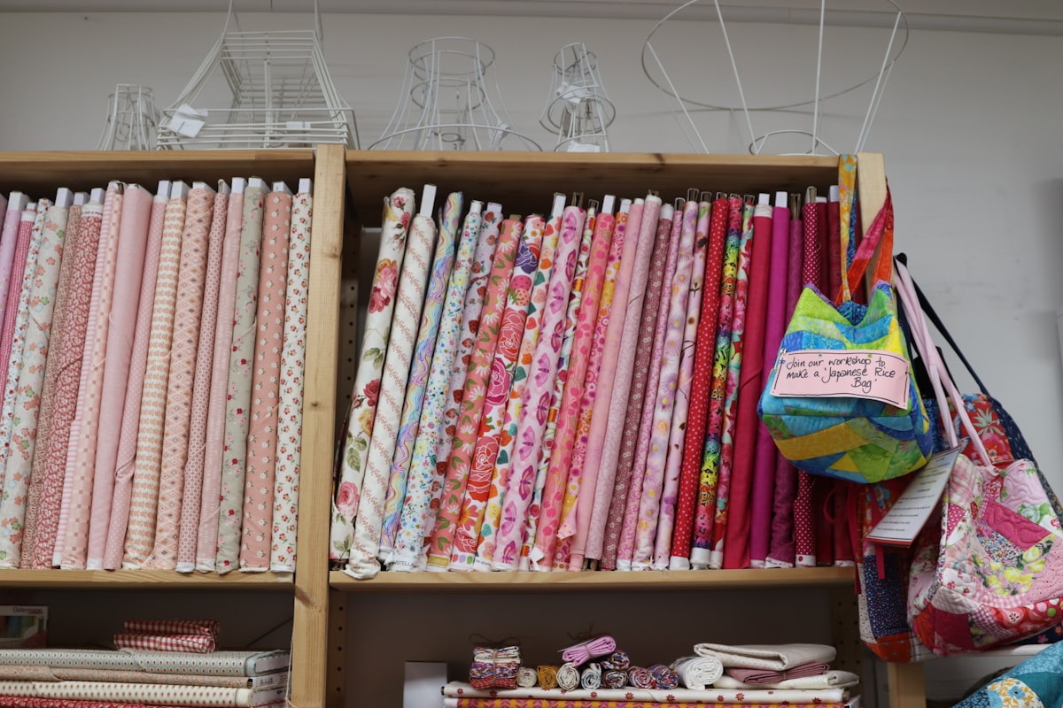 Shelves are filled with colorful fabric bolts. related to Pink Quilts and Coverlets