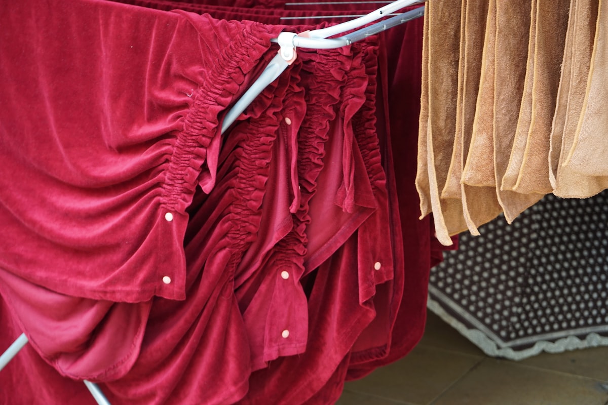 Shiny red table covers handing on a close line. related to Exquisite Royal Velvet Coverlets for the Modern Bedroom