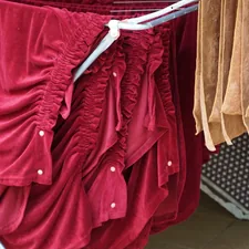 Shiny red table covers handing on a close line. related to Exquisite Royal Velvet Coverlets for the Modern Bedroom