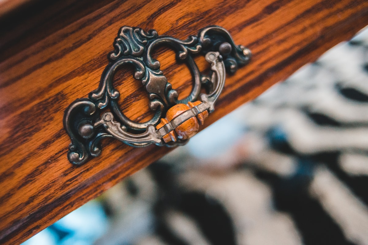 silver chain on brown wooden table related to Hollywood Regency Sideboard: A Gateway to Glamour
