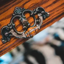 silver chain on brown wooden table related to Hollywood Regency Sideboard: A Gateway to Glamour