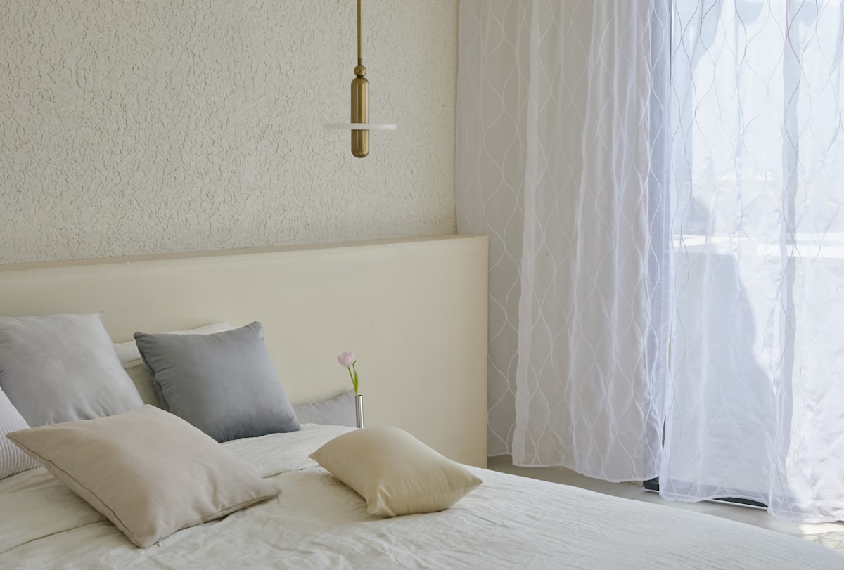Simple aesthetic in minimalist bedroom with white sheer curtains. related to Elevate Your Home with Linen Valances: Stylish Window Treatments