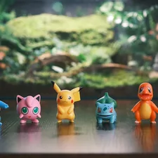 Six pokemon figurines lined up on a wooden surface. related to Transform Your Child's Room with a Pokemon Bed Set