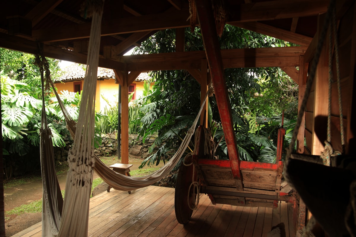 Small hut for coffee plantation workers to rest, with hammocks and an oxcart for carrying coffee. In the background, the plantation owners house. Conserved house of the 19th century  related to The Ultimate Relaxation Spot: Hanging Porch Beds 101