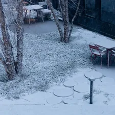 Snow covers an outdoor seating area with tables and chairs. related to Warming Your Outdoor Space with Terracotta Clay Chimineas