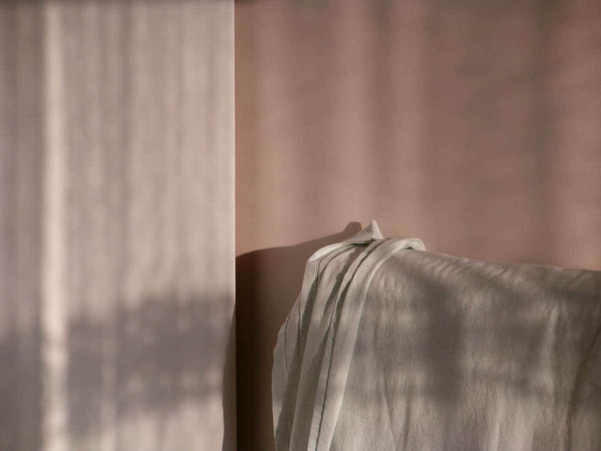 Soft fabric draped with dappled light patterns. related to Creating a Dream Bedroom with Solid Wood