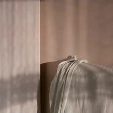 Soft fabric draped with dappled light patterns. related to Creating a Dream Bedroom with Solid Wood
