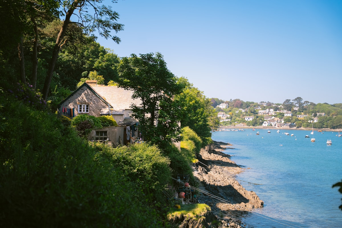 Stone cottage on a sunny hillside beside a blue bay. related to Unveiling the Charm of Harbor House Bedding: Style and Comfort