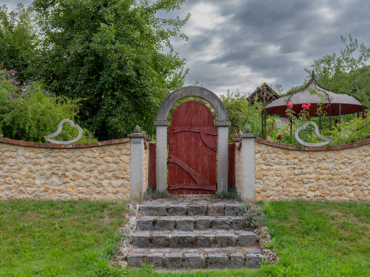 Stone steps lead to a rustic red wooden door. related to Transform Your Curb Appeal: Outdoor Entryway Ideas to Wow