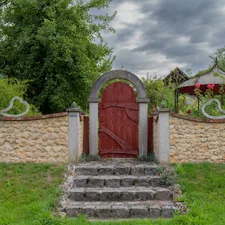 Stone steps lead to a rustic red wooden door. related to Transform Your Curb Appeal: Outdoor Entryway Ideas to Wow