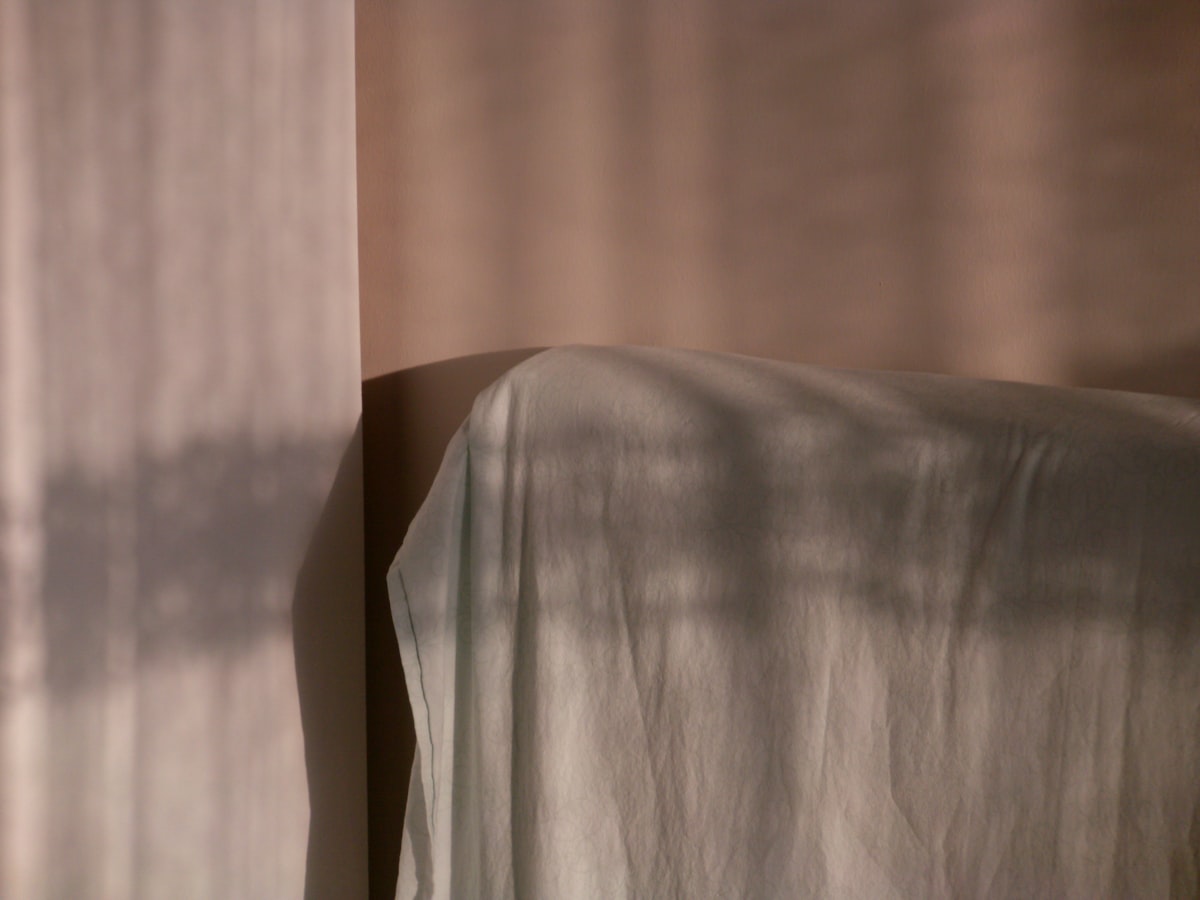 Sunlight casts shadows on a draped surface. related to Weaving Whimsy: A Guide to Magical Thinking Bedding