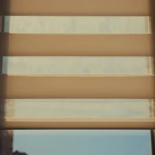 Sunlight shines through window blinds. related to Roller Shade Valances: Style and Function Combined