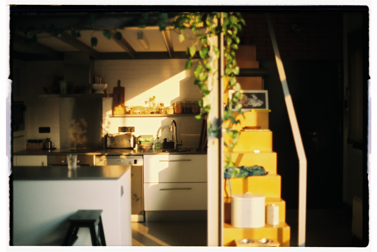Sunlight streams into a modern kitchen with yellow stairs. related to Brighten Up Your Kitchen with Sunflower Valance Kitchen Curtains
