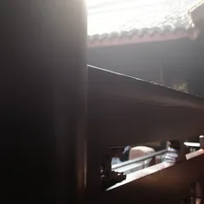 Sunlight streams through ornate wooden architecture related to Adding Warmth with a Dark Brown Sideboard