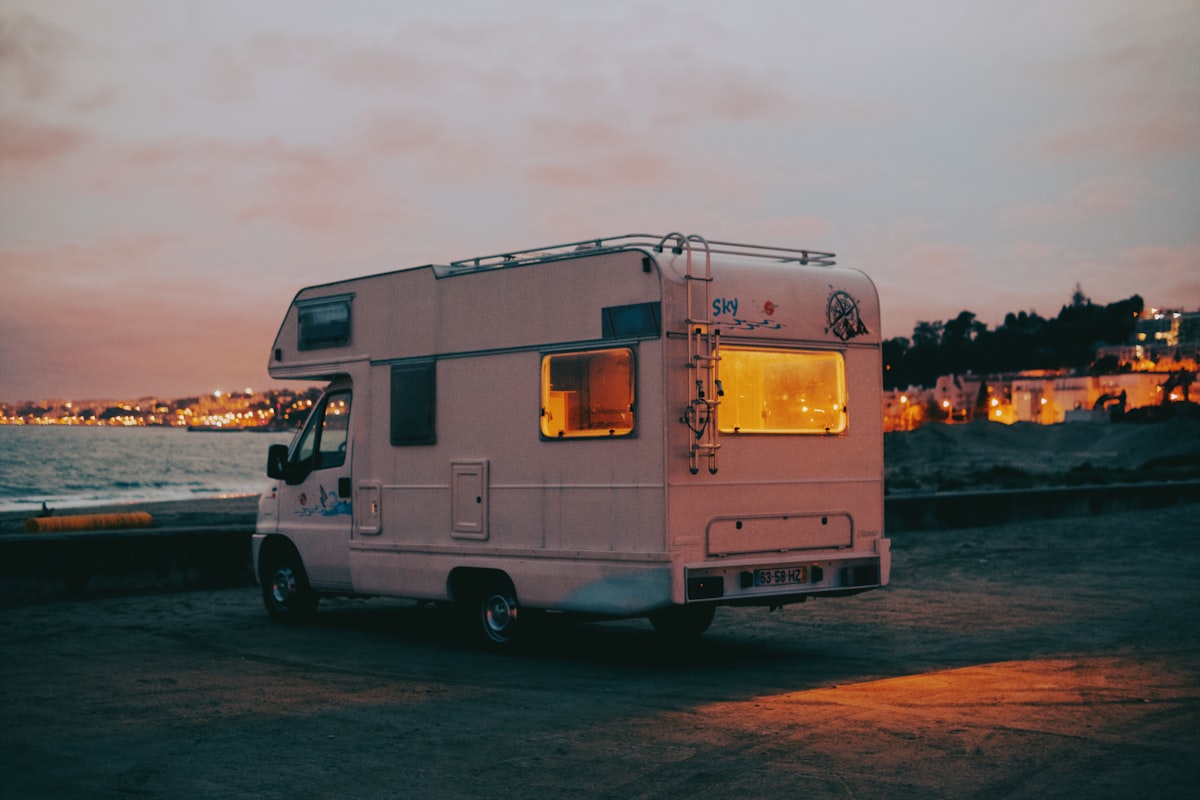 Sunset Nos Alive Lisbon Caravan Recreational Vehicles As the golden sun sets over the vast expanse of the Atlantic Ocean near Lisbon, Portugal, the scene is painted with hues of warm orange and soft pink. In the foreground stands a charming caravan, part of the lively atmosphere of the Nos Alive festival. This recreational vehicle, adorned with colorful banners and adorned with fairy lights, symbolizes the spirit of adventure and camaraderie that permeates the festival grounds. Against the backdrop of the Lisbon river merging into the Atlantic, the silhouette of the caravan coastal coast related to Maximizing Space in Your RV with a Murphy Bed