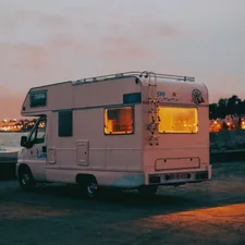 Sunset Nos Alive Lisbon Caravan Recreational Vehicles As the golden sun sets over the vast expanse of the Atlantic Ocean near Lisbon, Portugal, the scene is painted with hues of warm orange and soft pink. In the foreground stands a charming caravan, part of the lively atmosphere of the Nos Alive festival. This recreational vehicle, adorned with colorful banners and adorned with fairy lights, symbolizes the spirit of adventure and camaraderie that permeates the festival grounds. Against the backdrop of the Lisbon river merging into the Atlantic, the silhouette of the caravan coastal coast related to Maximizing Space in Your RV with a Murphy Bed