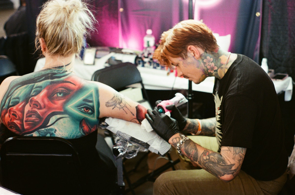 Tattoo artist working on a client's arm related to Chris Madden Valance: The Talented Singer-Songwriter