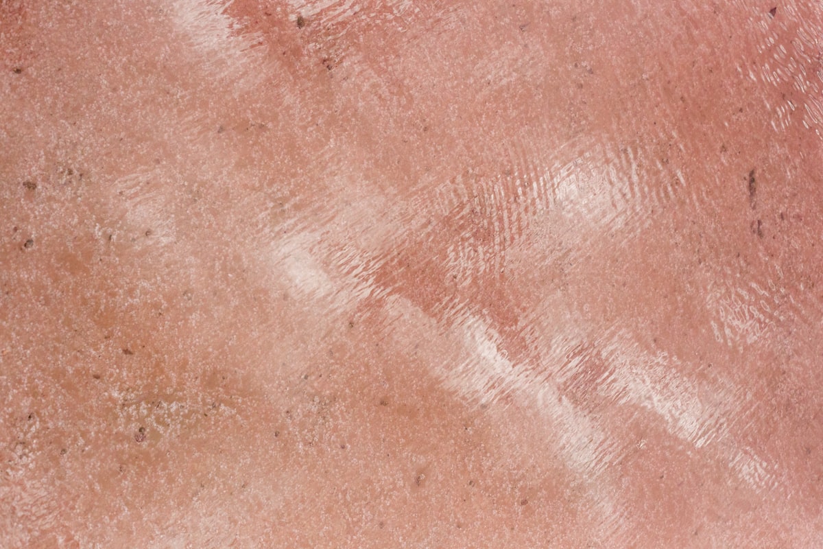 Textured pink surface with a reflective shine. related to Understanding Bed Bug Rash: Visual Insights
