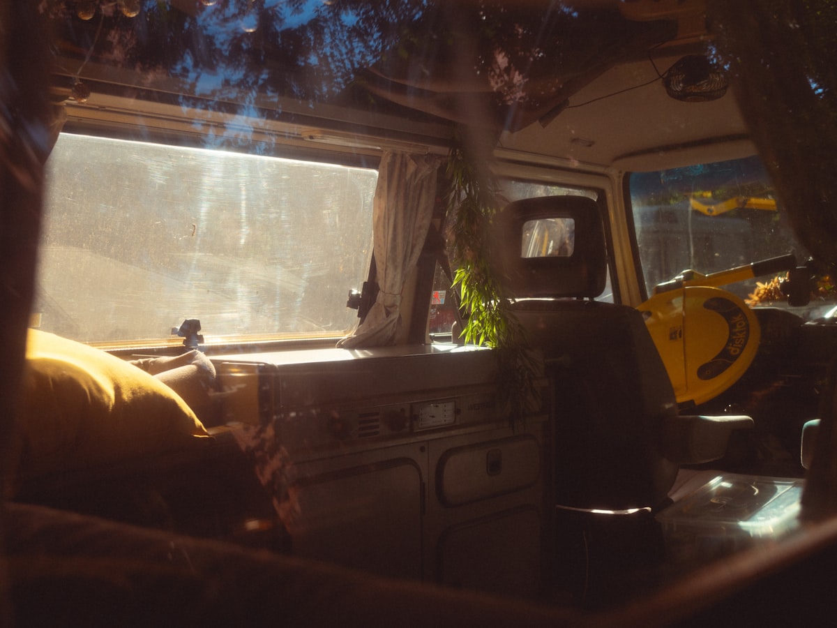 the interior of a camper van with the sun shining through the window related to The Ultimate Guide to VW Bus Beds