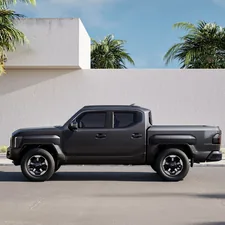 The left side view of the Kia Tasman parked in front of a building on a clear day. related to The Versatility and Advantages of Flat Bed Trucks