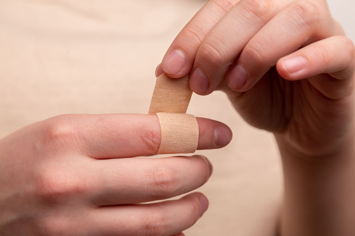 The man seals the wound with adhesive plaster. The medicine. Injury. Wound. Infection. First aid. Pain related to Coverlet Adhesive Bandages: A Guide to Effective Wound Care