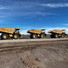 Three Caterpillar 777G mining haul trucks at work in Nevada. related to The Importance of Dump Truck Sideboards: Elevating Your Construction Experience