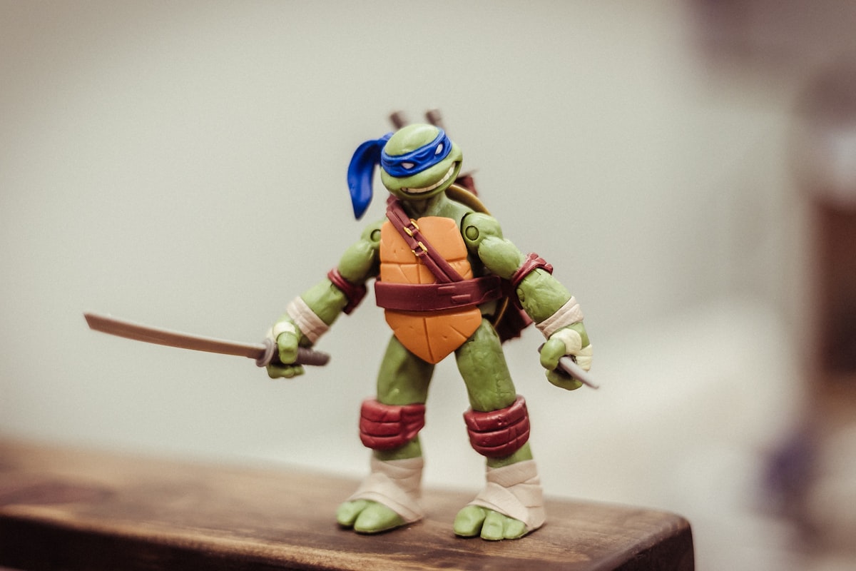 TMNT toy on brown wooden surface related to Cowabunga: Dive into the World of Ninja Turtle Bedding
