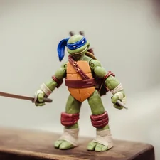 TMNT toy on brown wooden surface related to Cowabunga: Dive into the World of Ninja Turtle Bedding