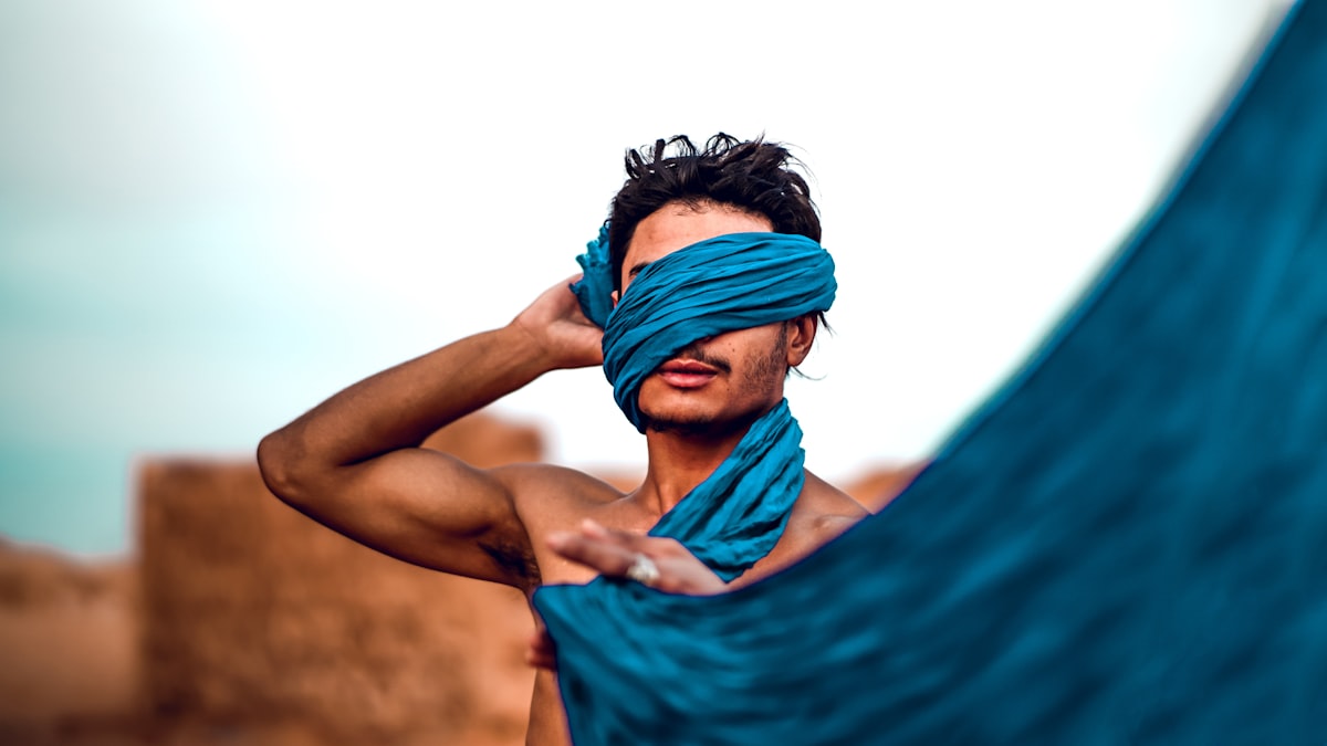 topless man holding blue textile related to 10 Creative Scarf Valance Ideas to Elevate Your Window Style