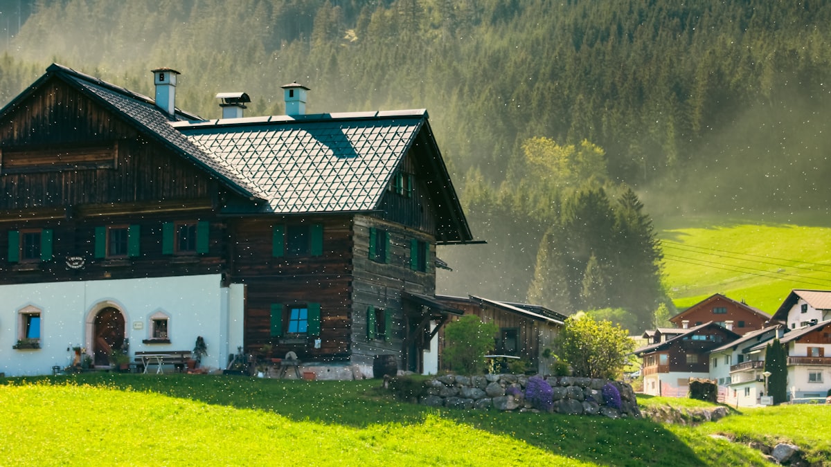Traditional wooden house on a green hillside with mountains. related to The Timeless Charm of Wooden Day Beds: A Perfect Blend of Comfort and Style