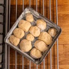 Tray of dinner rolls on a wooden counter. related to Elevate Your Gardening: A Step-by-Step Guide on How to Make a Raised Garden Bed