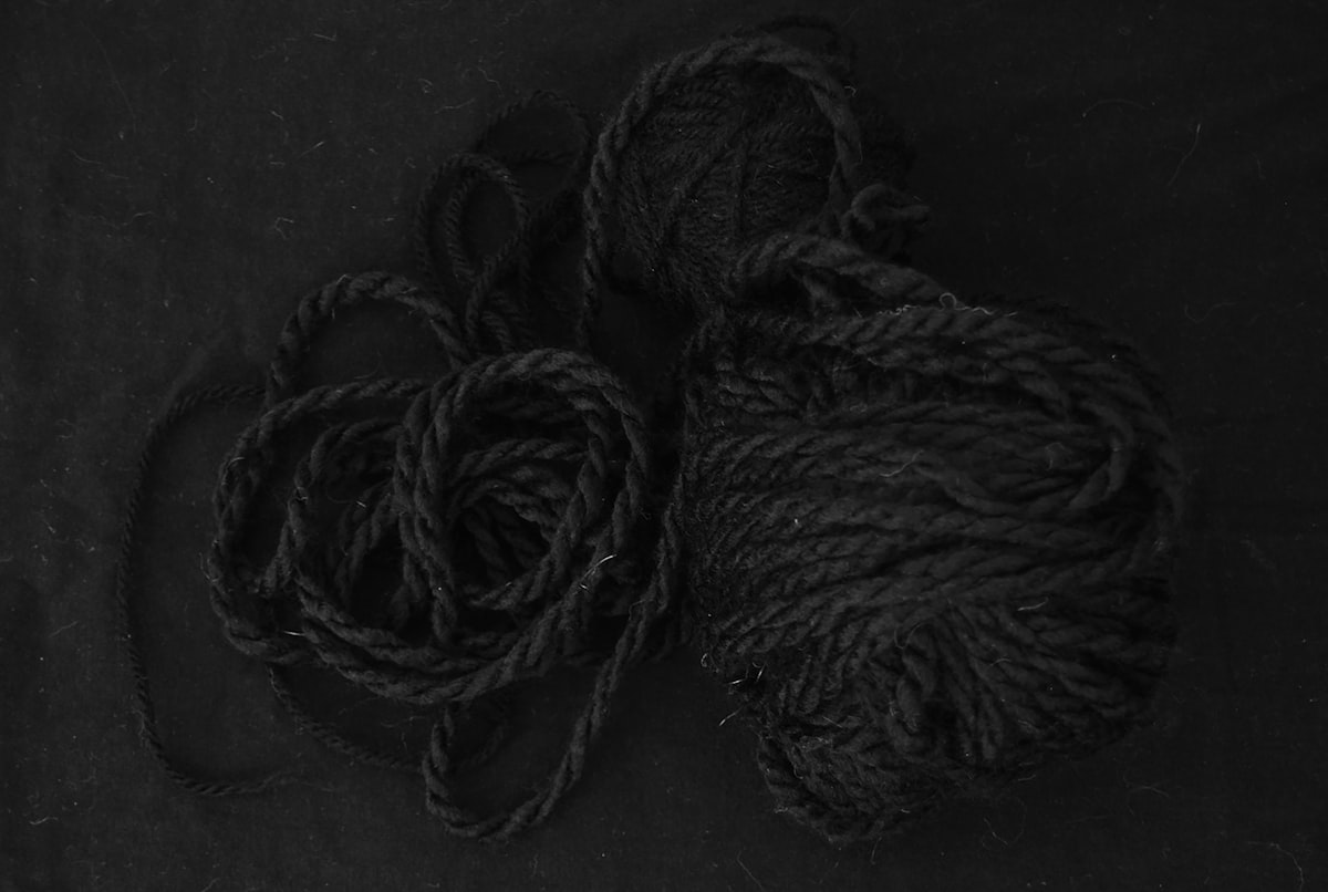 two balls of yarn on a black surface related to Snuggle Up in Style: Unraveling the Mystery of Duvet Coverlets
